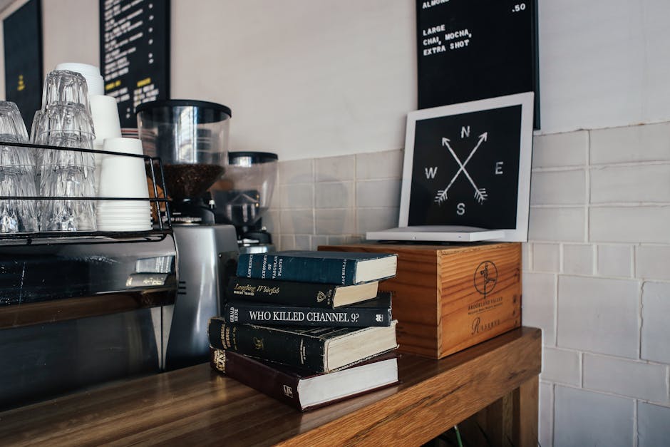 Inviting café interior featuring stacked books and coffee setup on a wooden counter.