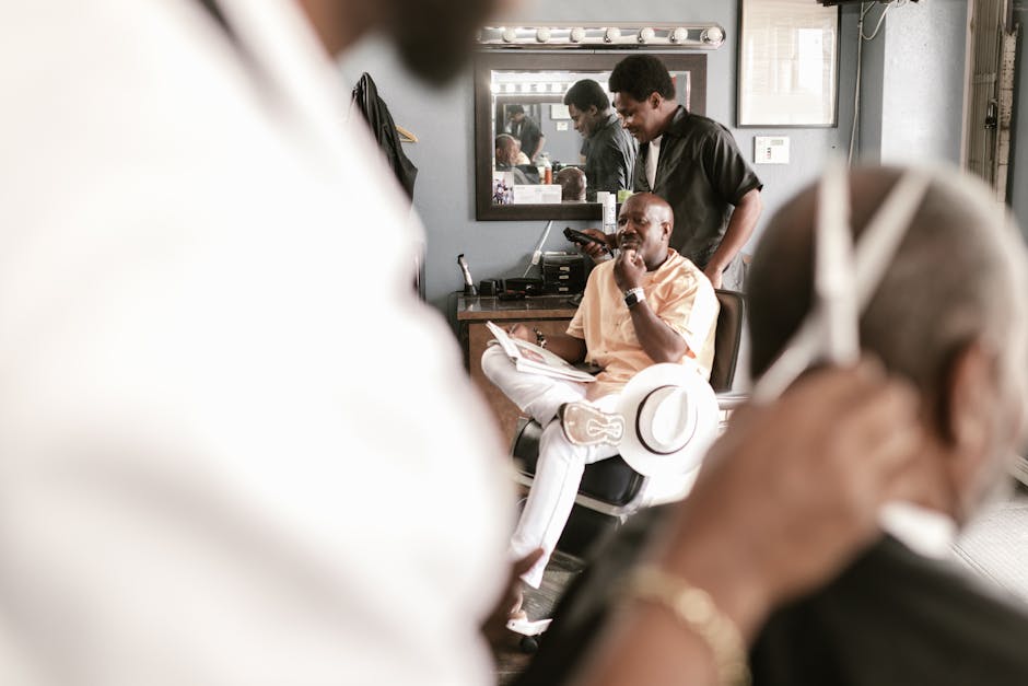 A lively barber shop with clients and barbers engaged, highlighting tools and mirror reflections.